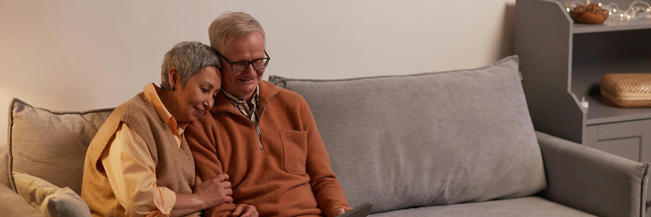 Zwei Senioren sitzen gemütlich auf dem Sofa