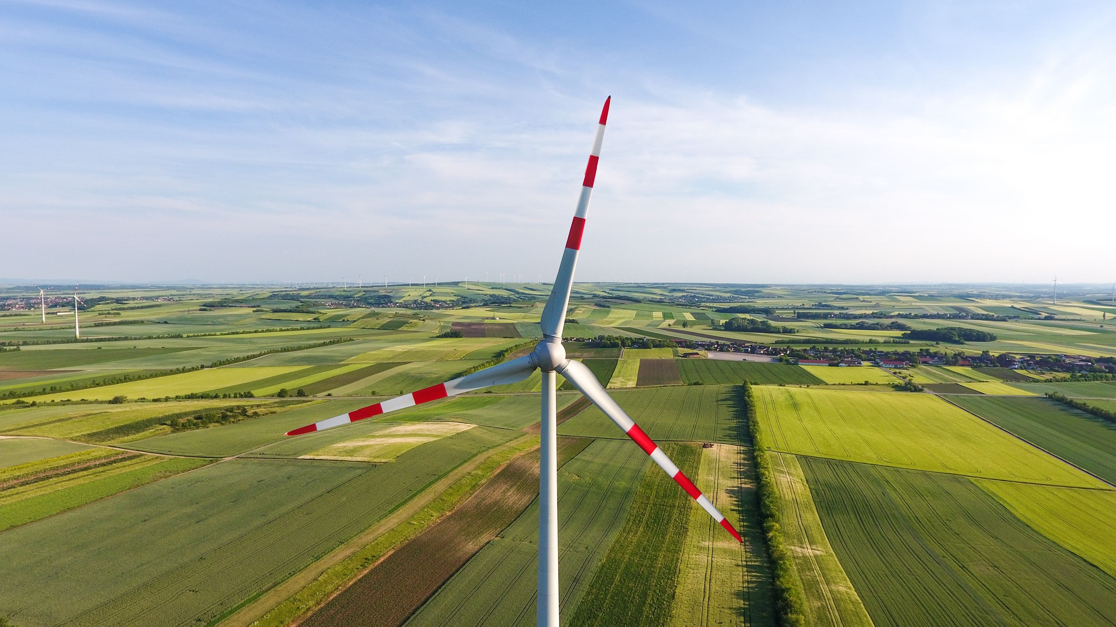 Ein Windrad vor Feldern