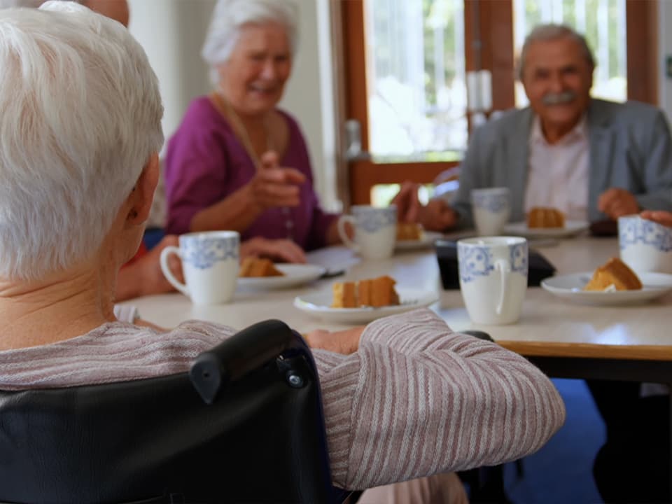 Eine weibliche Person pflegt Kräuter auf ihrem Balkon