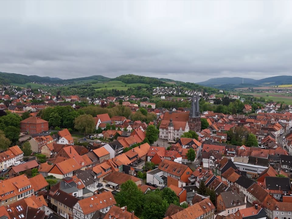 Eine weibliche Person pflegt Kräuter auf ihrem Balkon